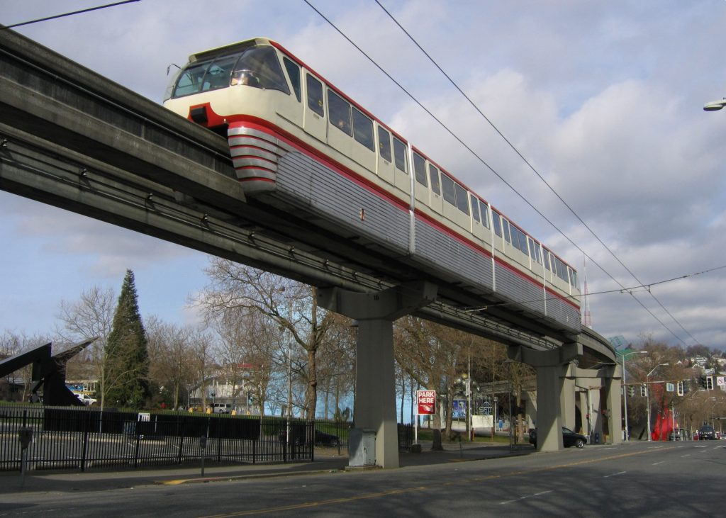 The red monorail train passing over 5th Avenue